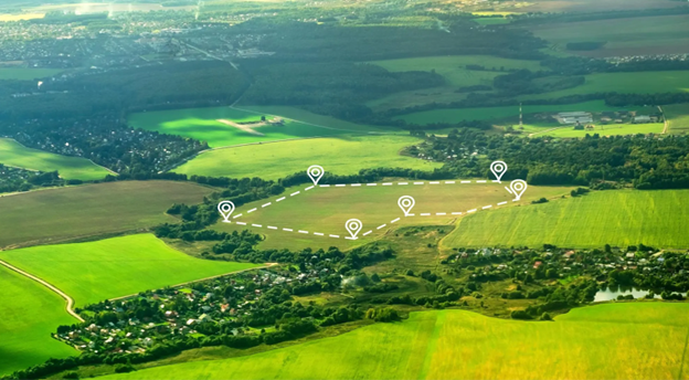 A field of land available for purchase with white markers surrounding its borders